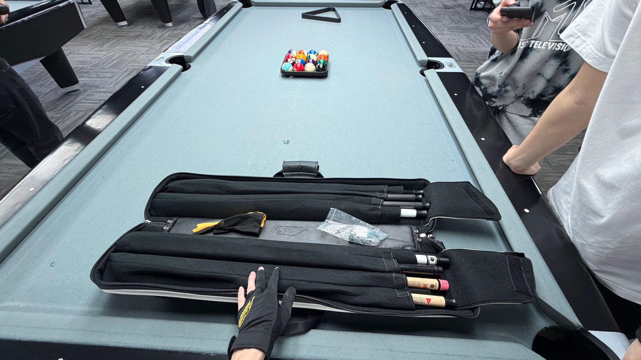 Jack lining up a shot, cue level, at a full-size professional pool table.