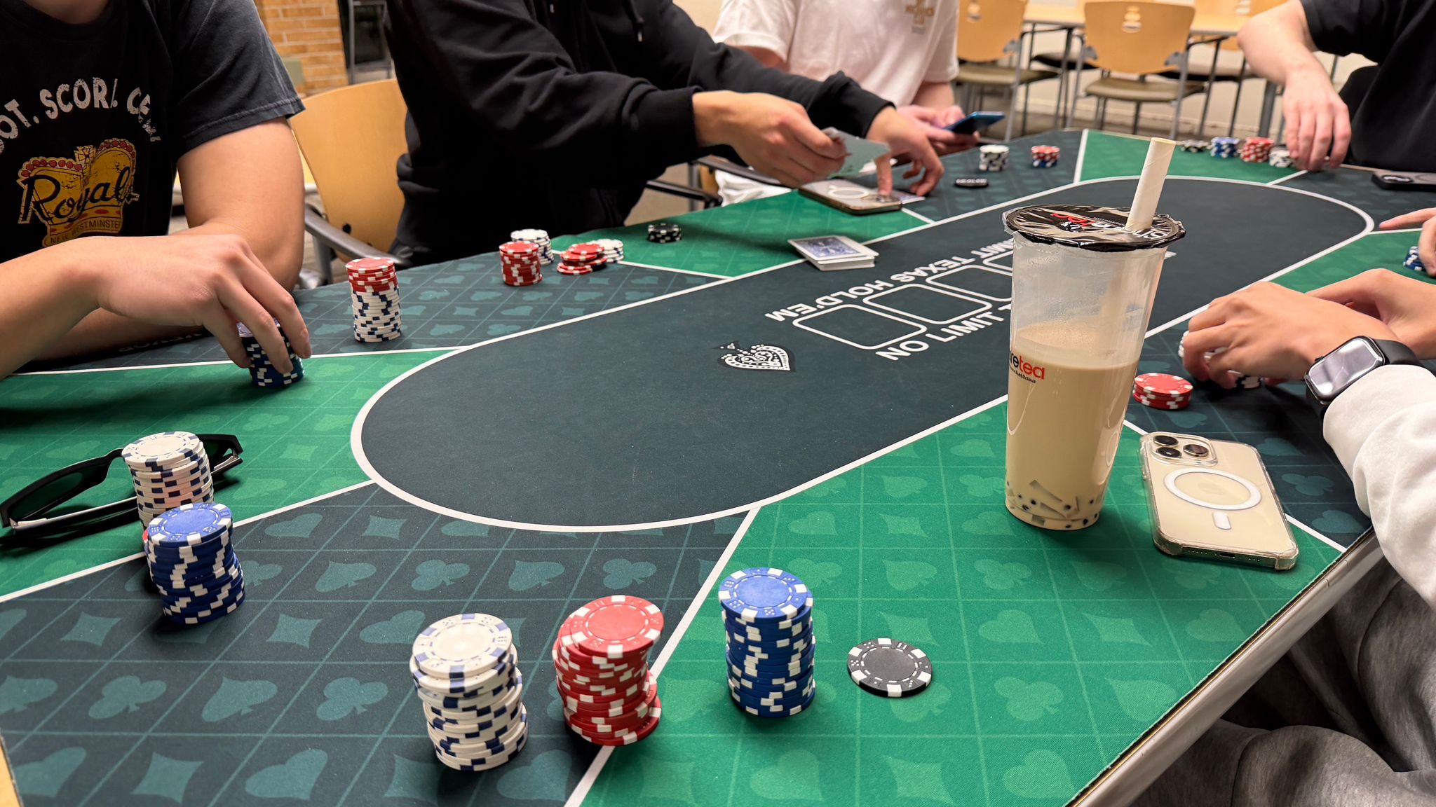 Playing cards and chips spread on a table during a poker game with friends after exams.