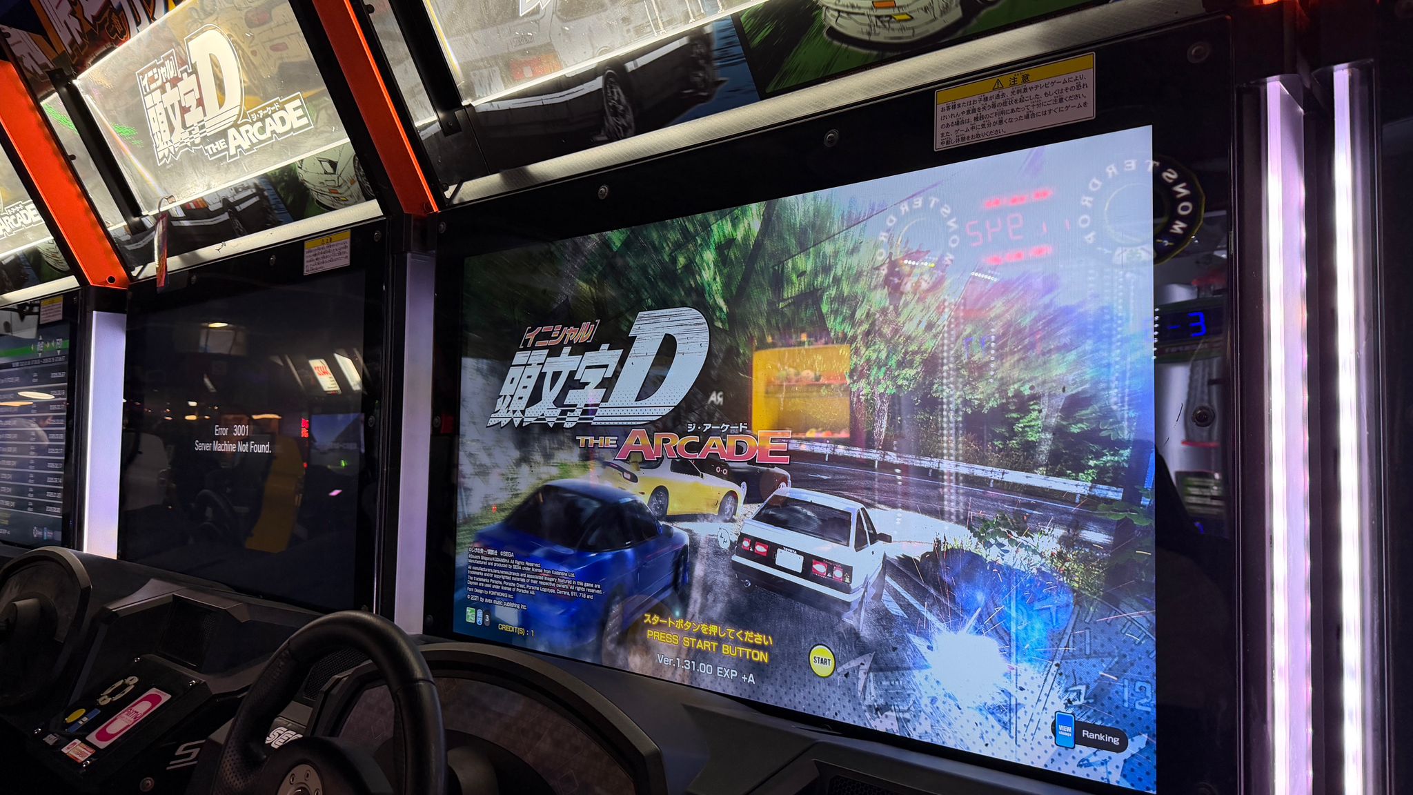 Jack and his dad seated at adjacent arcade racing-game cabinets.